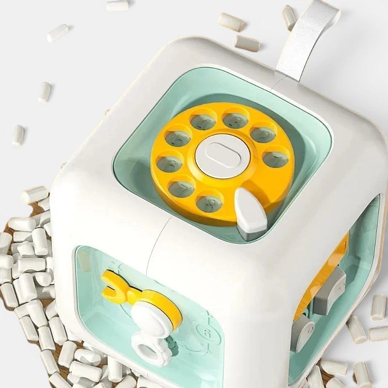 Cube d'activités Petit Éveil Montessori 6 en 1, jouet éducatif sensoriel blanc et vert pour le développement bébé.