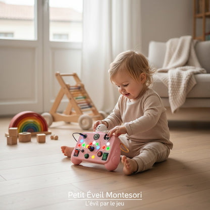 Petit Éveil Montessori, tableau d'activités interactif rose avec lumières LED, boutons, interrupteurs et boussole pour l'apprentissage des tout-petits.