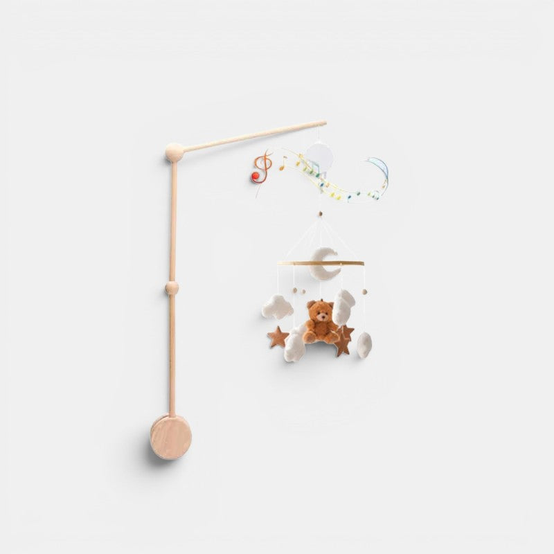 Petit Éveil Montessori arche en bois avec mobile musical, lune, nuages, étoiles et ours en peluche marron.