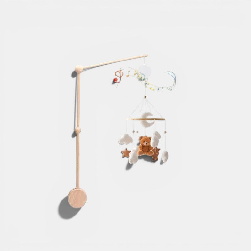 Petit Éveil Montessori arche en bois avec mobile musical, lune, nuages, étoiles et ours en peluche marron.