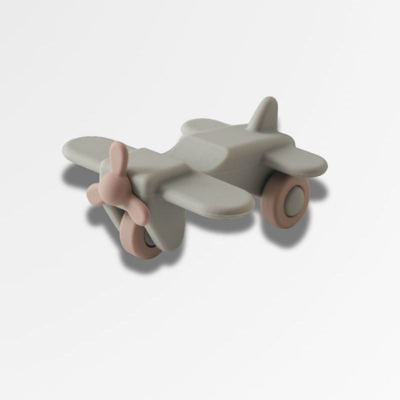 Petit Éveil Montessori avion jouet en silicone gris et rose, hélice et roues, pour bébé.