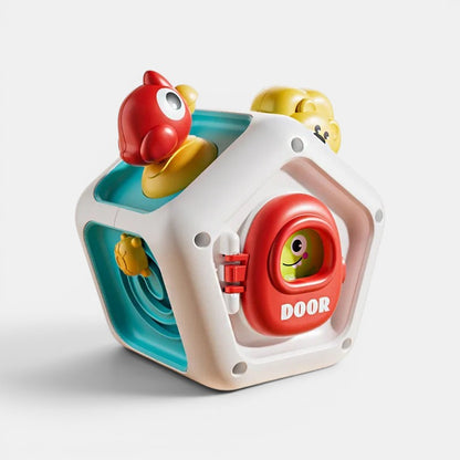 Cube d'activités Montessori Petit Éveil Montessori avec porte rouge, oiseau rouge et jaune, et visage souriant.