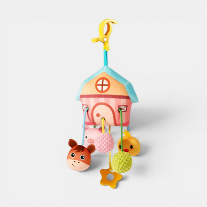 Hochet suspendu Petit Éveil Montessori en forme de maisonnette rose avec des animaux : cheval, cochon, poussin, et des balles texturées.