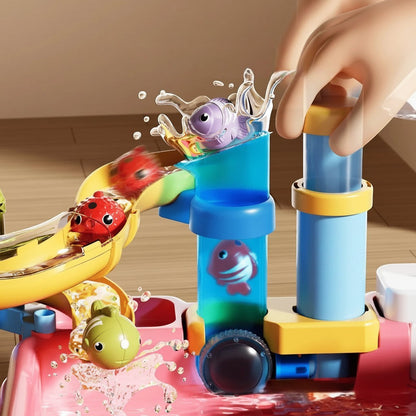 Petit Éveil Montessori : Jouet de bain aquatique coloré avec toboggan, boules et poissons pour stimuler l'éveil sensoriel.