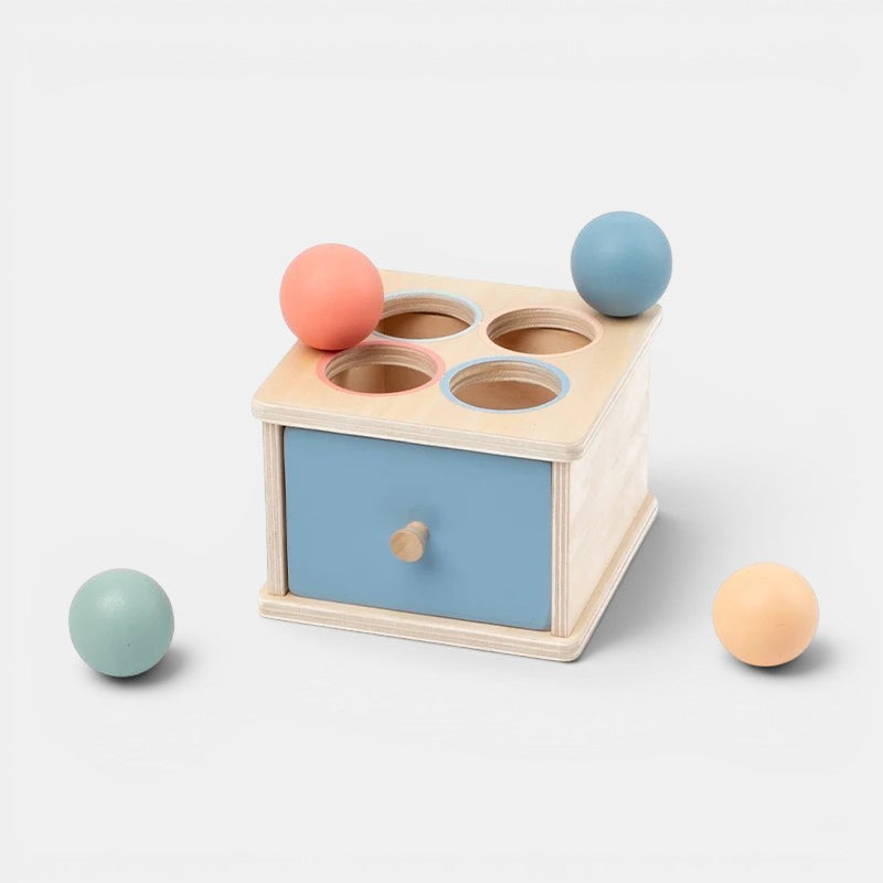 Petit Éveil Montessori : jouet en bois de tri de formes et couleurs avec 4 trous et 4 balles pastel.
