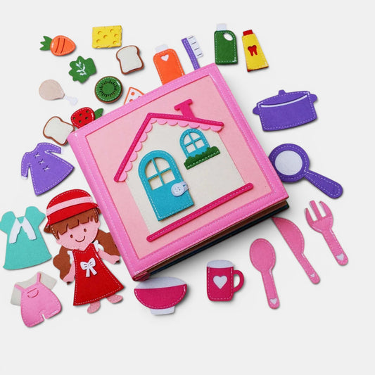 Livre d'activités Montessori en feutrine rose pour la vie quotidienne, avec des accessoires détachables : maison, enfant, vêtements, nourriture et ustensiles de cuisine. Petit Éveil Montessori.