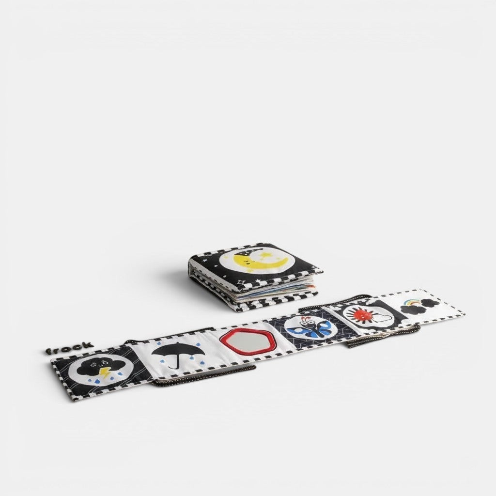 Livre sensoriel en tissu Petit Éveil Montessori noir et blanc avec des illustrations de lune, parapluie, papillon et soleil pour bébé.