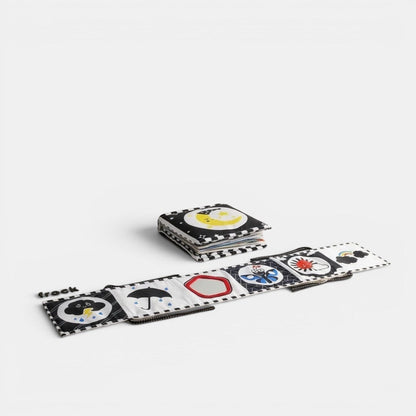 Livre sensoriel en tissu Petit Éveil Montessori noir et blanc avec des illustrations de lune, parapluie, papillon et soleil pour bébé.
