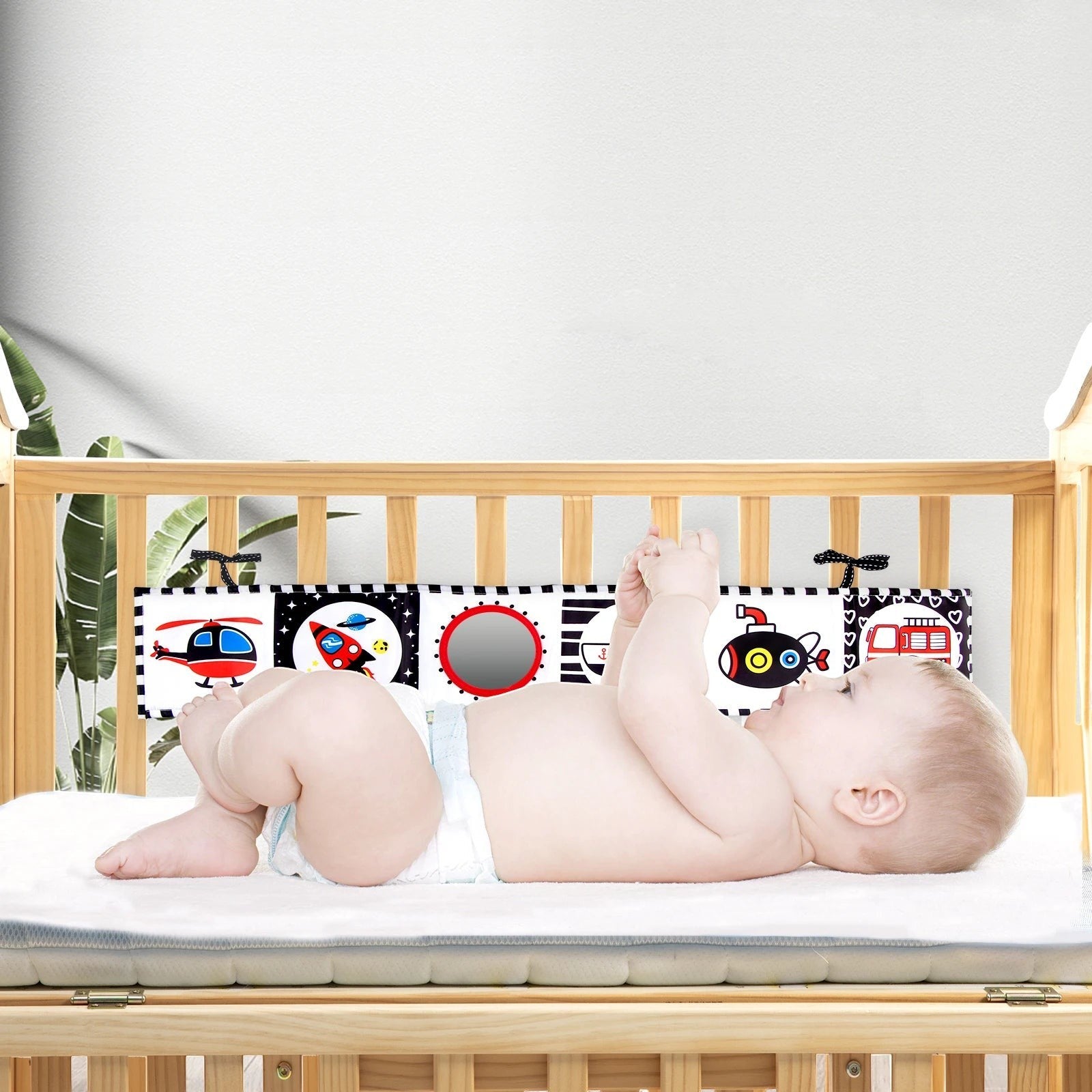 Livre sensoriel noir et blanc Petit Éveil Montessori avec des illustrations de véhicules et un miroir pour bébé.