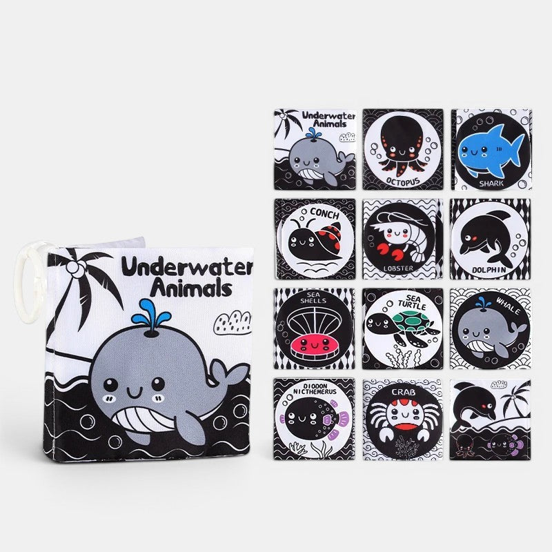 Livre en tissu Petit Éveil Montessori sur les animaux marins, noir et blanc avec baleine, poulpe, requin, crabe, tortue, dauphin.