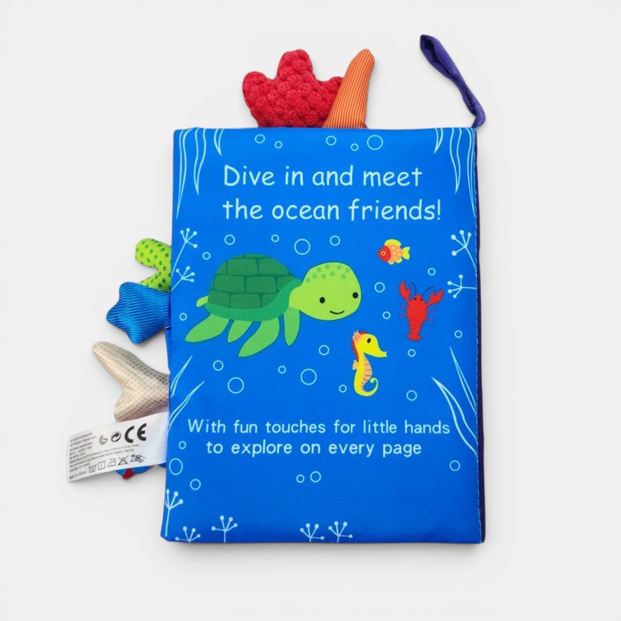 Livre en tissu Petit Éveil Montessori bleu avec une tortue, un hippocampe, un poisson et un homard. Touches amusantes pour les petites mains.