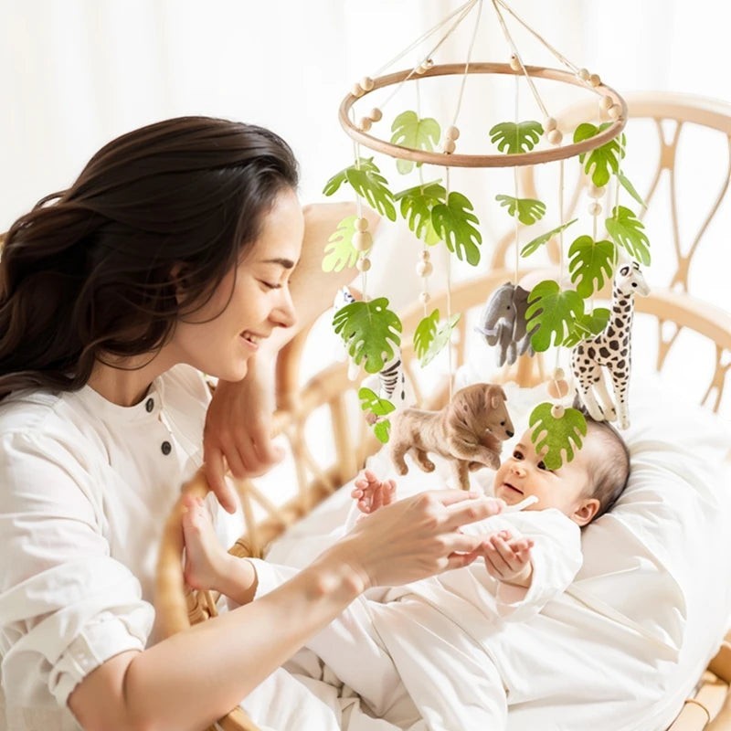 Petit Éveil Montessori mobile en feutre pour berceau avec animaux de la savane et feuilles vertes, idéal pour l'éveil de bébé.