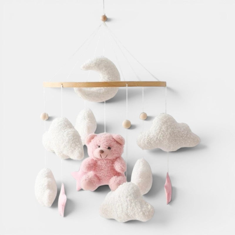 Petit Éveil Montessori mobile en feutre avec un ours rose, des nuages blancs et une lune pour berceau.