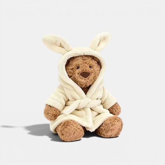 Ours en peluche marron doux portant une robe de chambre blanche à capuche avec des oreilles de lapin, style Montessori, Petit Éveil Montessori.