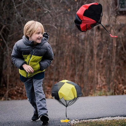 Petit Éveil Montessori : enfant jouant avec des parachutes colorés, jeu d'extérieur pour développer la coordination.