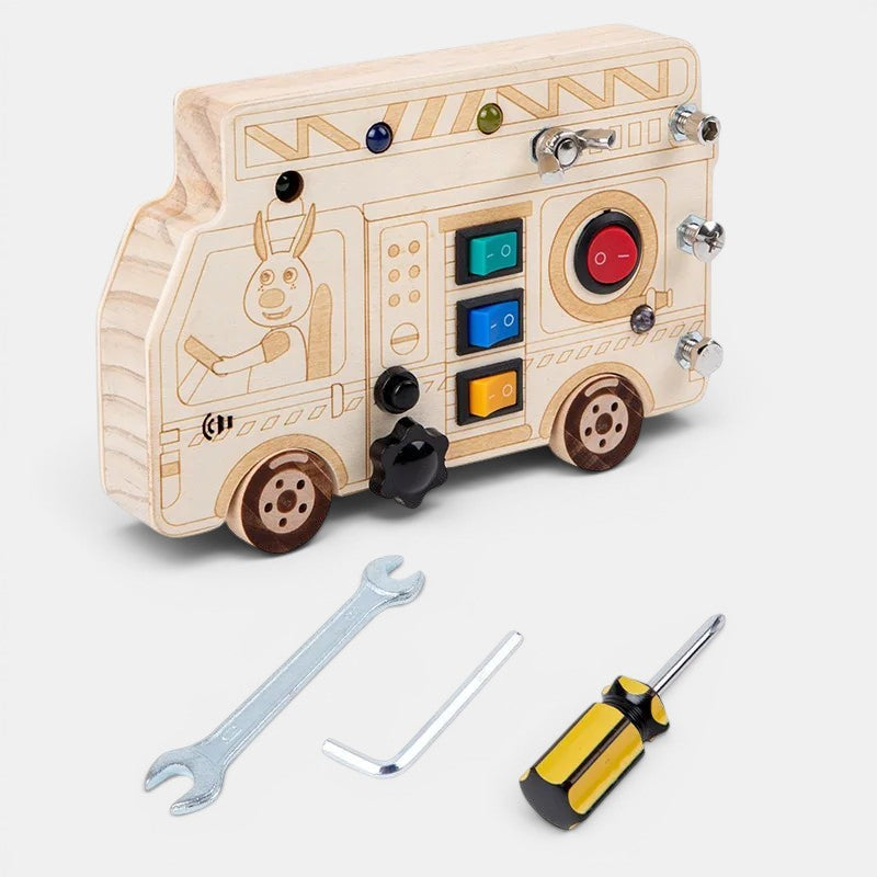 Planche occupée en bois Petit Éveil Montessori en forme de camion avec interrupteurs, boutons et outils pour enfants.