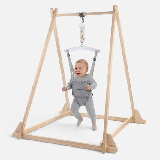 Bébé souriant utilisant le sauteur en bois Petit Éveil Montessori avec siège réglable et cadre en pin naturel