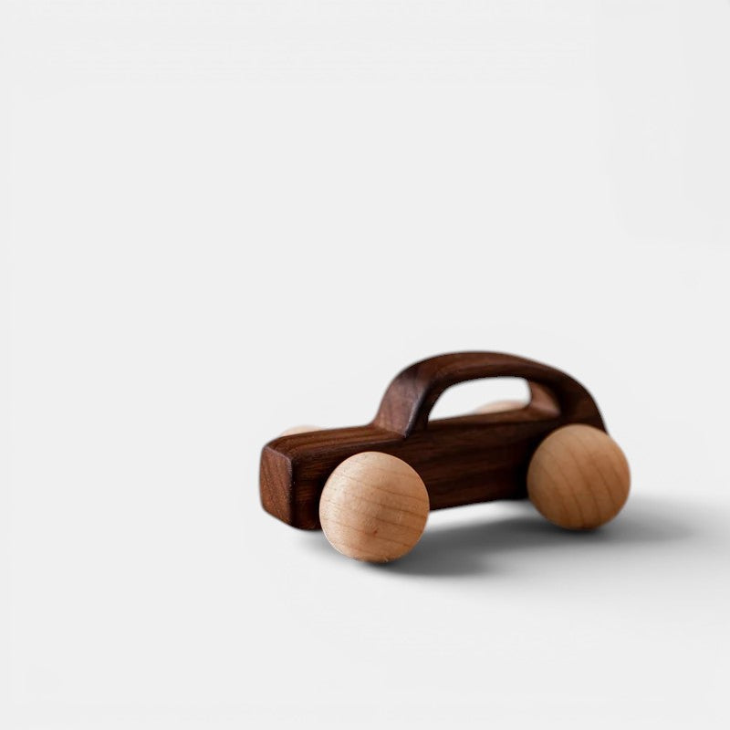 Voiture Montessori en bois foncé avec roues en bois clair, jouet éducatif pour enfants.